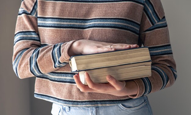 Una giovane studentessa con libri in mano nella stanza