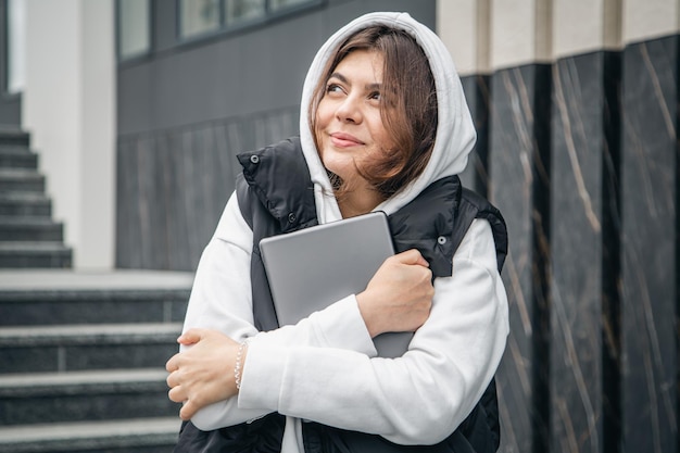 Una giovane studentessa sta con una tavoletta digitale nelle sue mani fuori