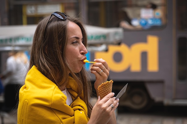 Una giovane turista mangia il gelato durante una passeggiata in città