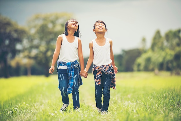 Una mano di due bambine che tiene insieme divertendosi nel parco