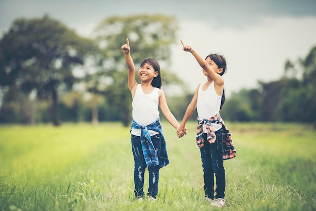 Una mano di due bambine che tiene insieme divertendosi nel parco