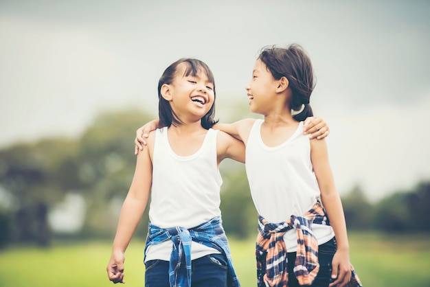 Una mano di due bambine che tiene insieme divertendosi nel parco