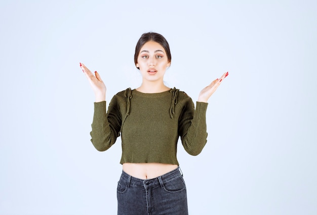 Una modella scioccata che guarda la telecamera e le mostra le mani vuote.