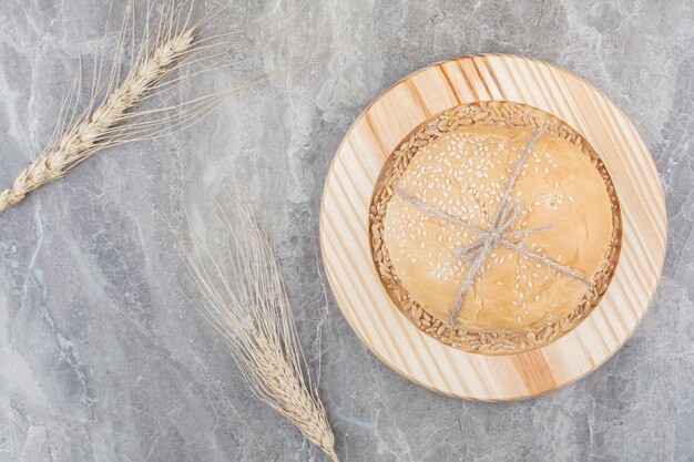 Una pagnotta di pane bianco con chicchi di avena su tavola di legno