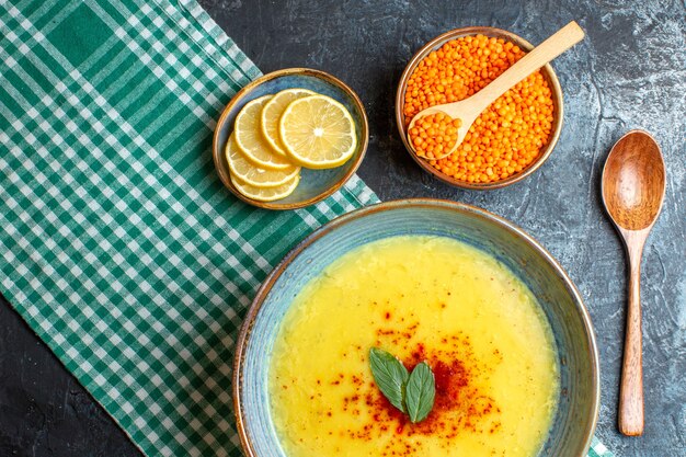 Una pentola blu con zuppa gustosa servita con menta e pepe su un asciugamano spogliato verde