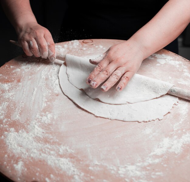 Una persona che produce pasta di lavash con farina.