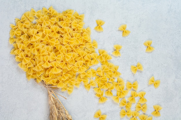 Una pila di pasta farfallino, sulla superficie di marmo