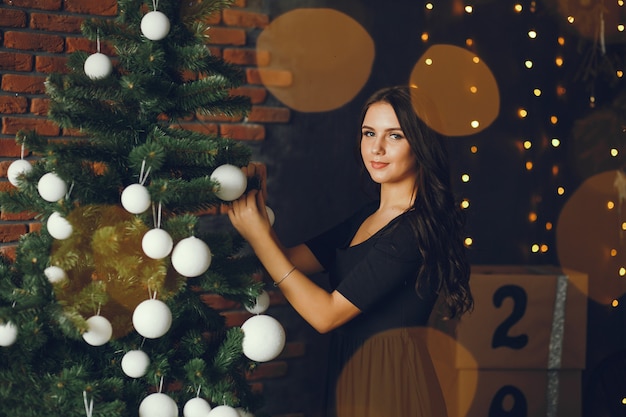 Una ragazza decora un albero di Natale