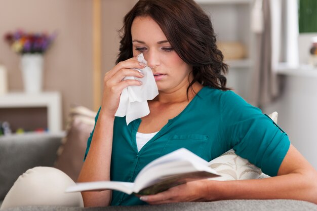 una ragazza legge un libro triste