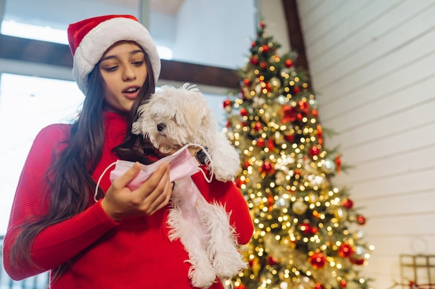 Una ragazza tiene un piccolo cane sulle sue mani a capodanno capodanno con un amico