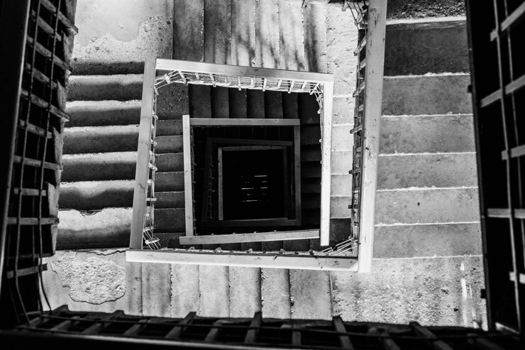 Foto gratuito una ripresa a cielo aperto di una scala a chiocciola in bianco e nero