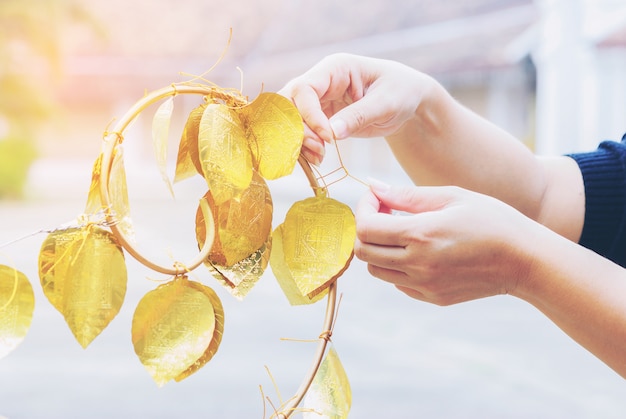 Una signora appende la foglia d&#39;oro che desidera la felicità a Wat Phrathat Chae Haeng