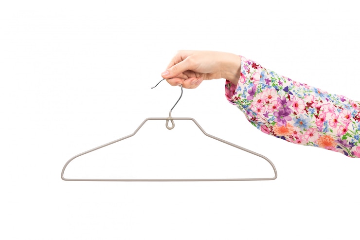 Foto gratuito una signora femminile della mano di vista frontale in camicia colorata del fiore progettata che tiene l'argento appende sul bianco