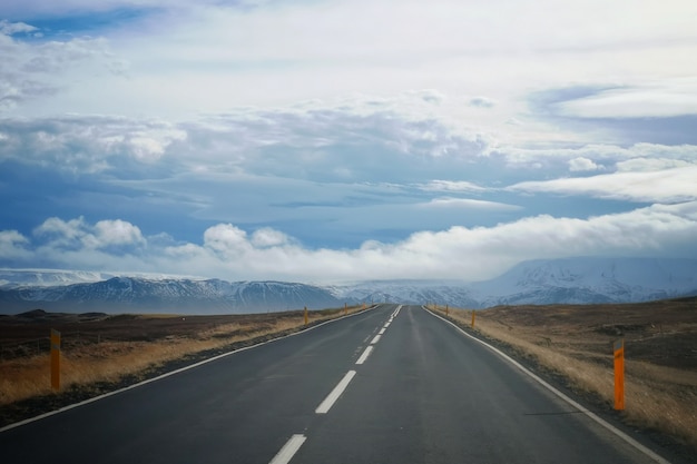 Una strada in un campo con un bel cielo nuvoloso