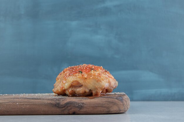 Una tavola di legno con carne di pollo fritta deliziosa.