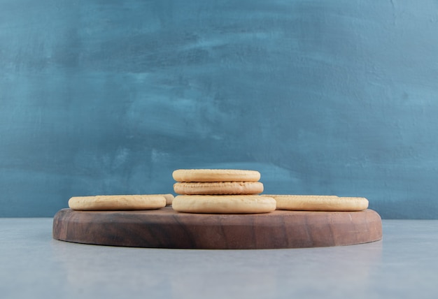 Una tavola di legno con dolci biscotti rotondi.