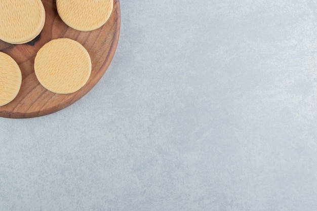 Una tavola di legno con dolci biscotti rotondi.