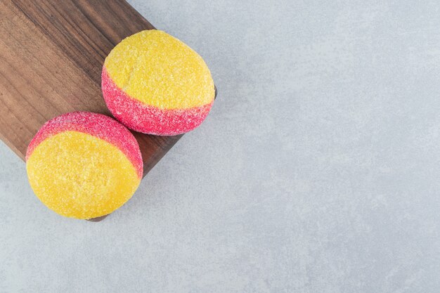 Una tavola di legno di biscotti dolci colorati.