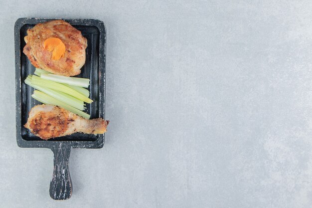 Una tavola di legno di carne fritta di pollo.