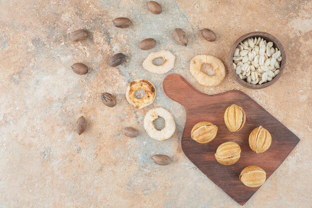 Una tavola di legno piena di biscotti dolci e una tazza di tisana