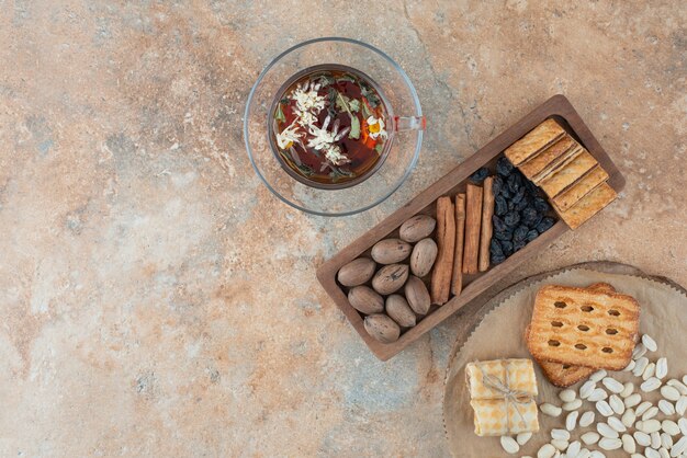 Una tavola di legno piena di biscotti dolci e una tazza di tisana