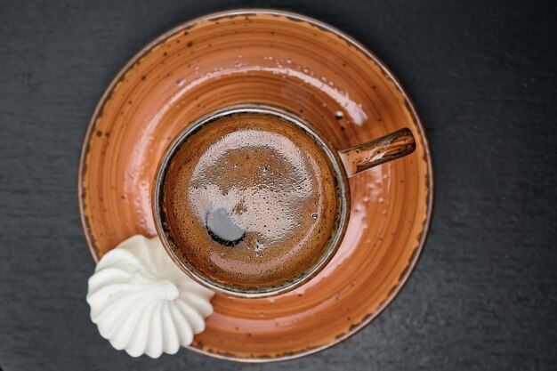 Una tazza con un forte caffè turco su un vecchio tavolo nero accanto alla vista dall'alto di bizet