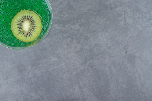 Una tazza di bicchiere da cocktail di succo di kiwi con una fetta di frutta. Foto di alta qualità