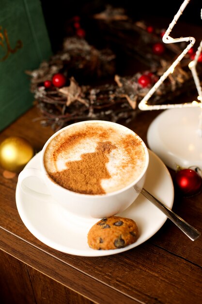 Una tazza di caffè con arte del latte dell'albero di Natale