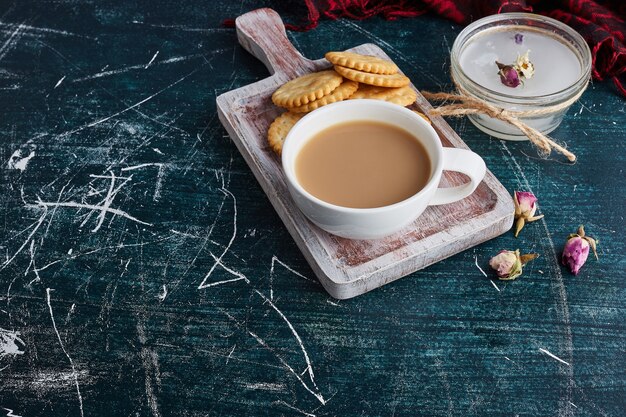 Una tazza di caffè con biscotti in giro.