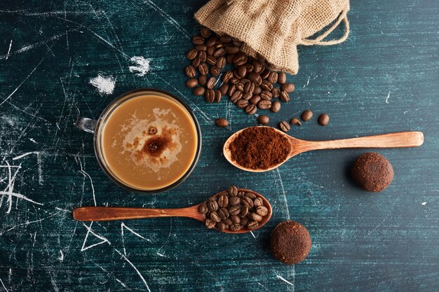 Una tazza di caffè con fagioli e biscotti.