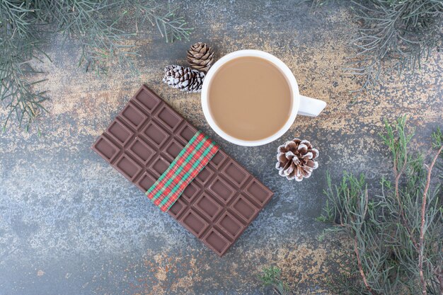 Una tazza di caffè con pigne e cioccolato. Foto di alta qualità