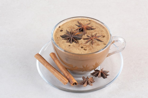 Una tazza di caffè dall'aroma gustoso con bastoncini di cannella e anice stellato. Foto di alta qualità