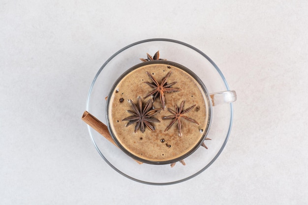 Una tazza di caffè dall'aroma gustoso con bastoncini di cannella e anice stellato