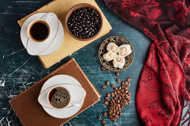 Una tazza di caffè su vecchi libri, vista dall'alto.