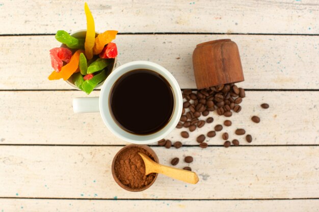 Una tazza di caffè vista dall'alto in tazza bianca con semi di caffè marroni freschi