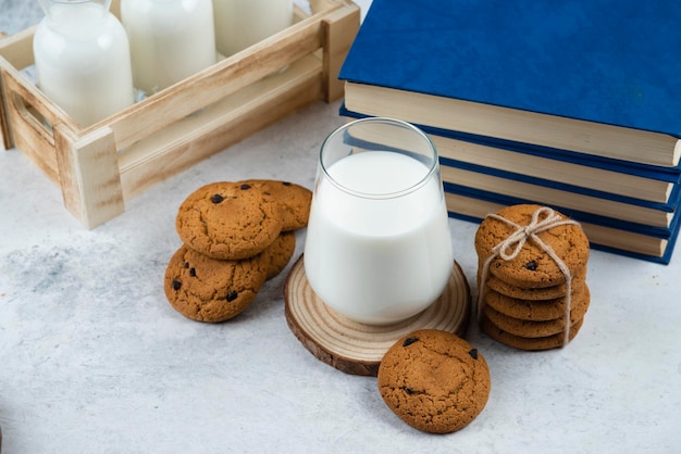 Una tazza di latte con biscotti al cioccolato su una tavola di legno.