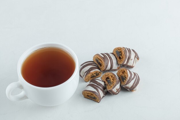 Una tazza di tè aromatico con barrette di cioccolato.