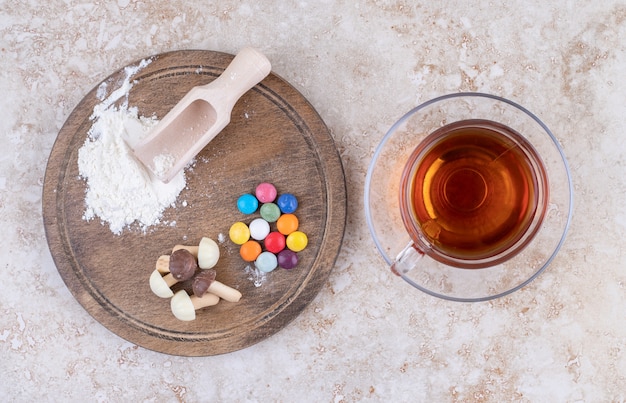 Una tazza di tè caldo con caramelle colorate