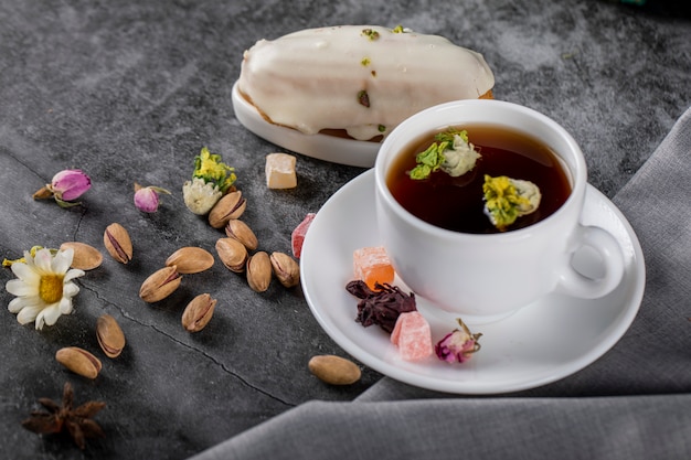 Una tazza di tè con noci e fiori in fiore