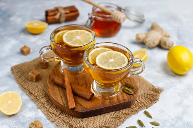 Una tazza di tè, zucchero di canna, miele e limone su cemento. Vista dall'alto, copia spazio