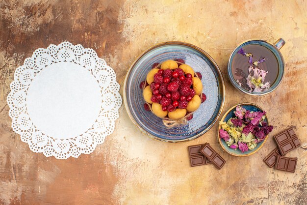 Una tazza di torta morbida tisana calda con frutta fiori barrette di cioccolato e tovagliolo