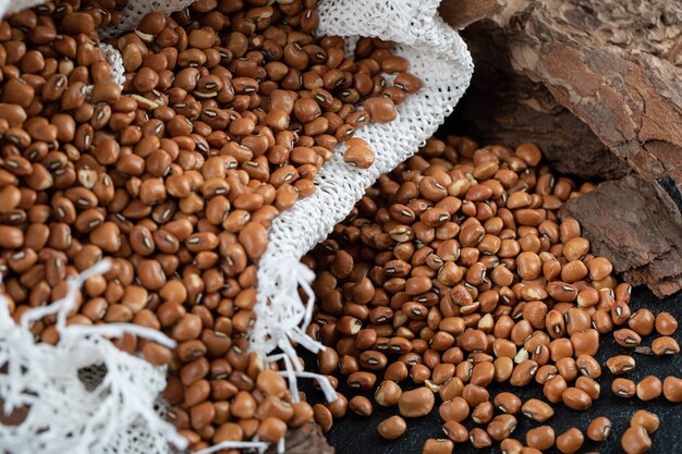 Una tela bianca con fagioli nani marroni non preparati