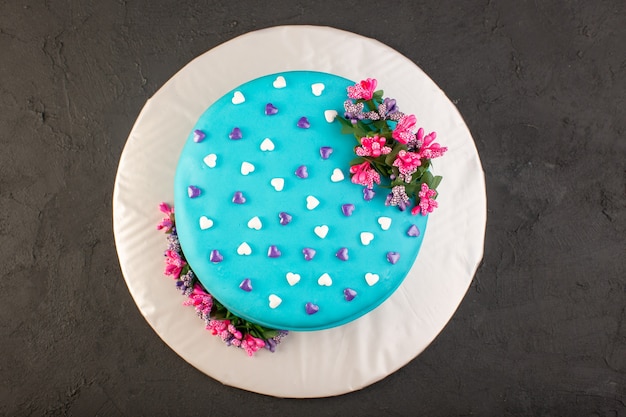 Una torta di compleanno blu con vista dall'alto con fiore in cima