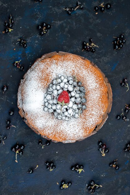 Una torta di frutta vista dall'alto deliziosa e rotonda formata con blu fresco, frutti di bosco su fondo scuro, zucchero dolce biscotto