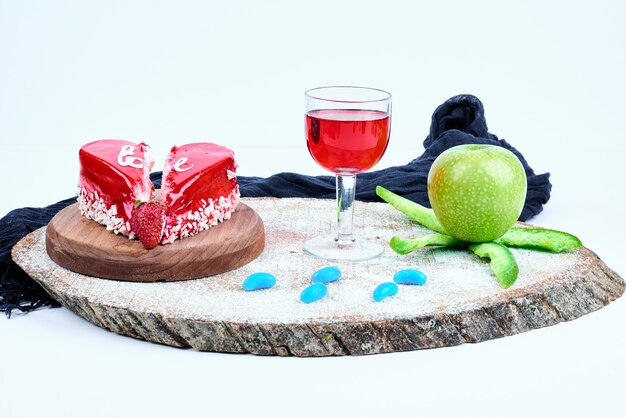 Una torta di San Valentino rosso con un bicchiere di bevanda.