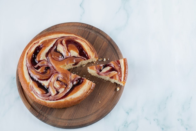 Una torta dolce alla vaniglia con ingredienti su un piatto di legno rustico