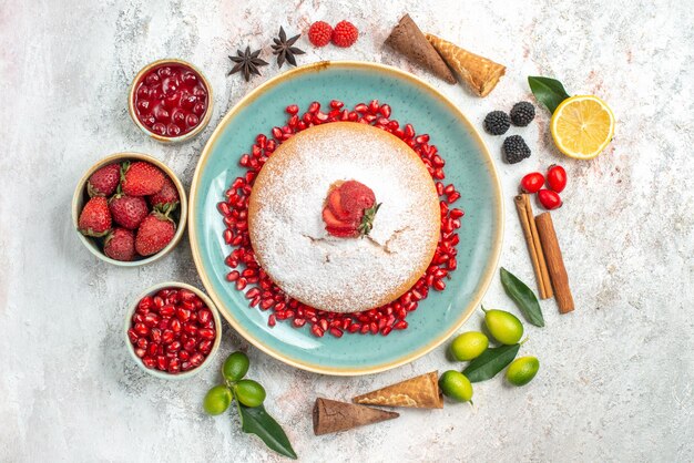 una torta una torta con melograno bastoncini di cannella ciotole di frutti di bosco lime anice stellato