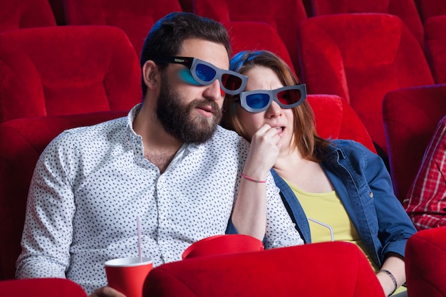 Una varietà di emozioni umane di amici che tengono una cola e popcorn al cinema.