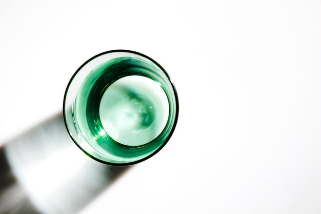 Una vista aerea di acqua nel vetro verde su sfondo bianco