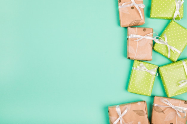 Una vista aerea di carta regalo marrone e verde avvolto scatole regalo sullo sfondo verde